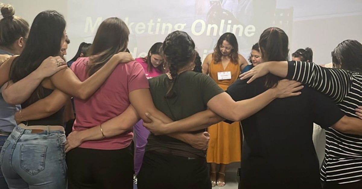 Roda de mulheres abraçadas em atividade coletiva