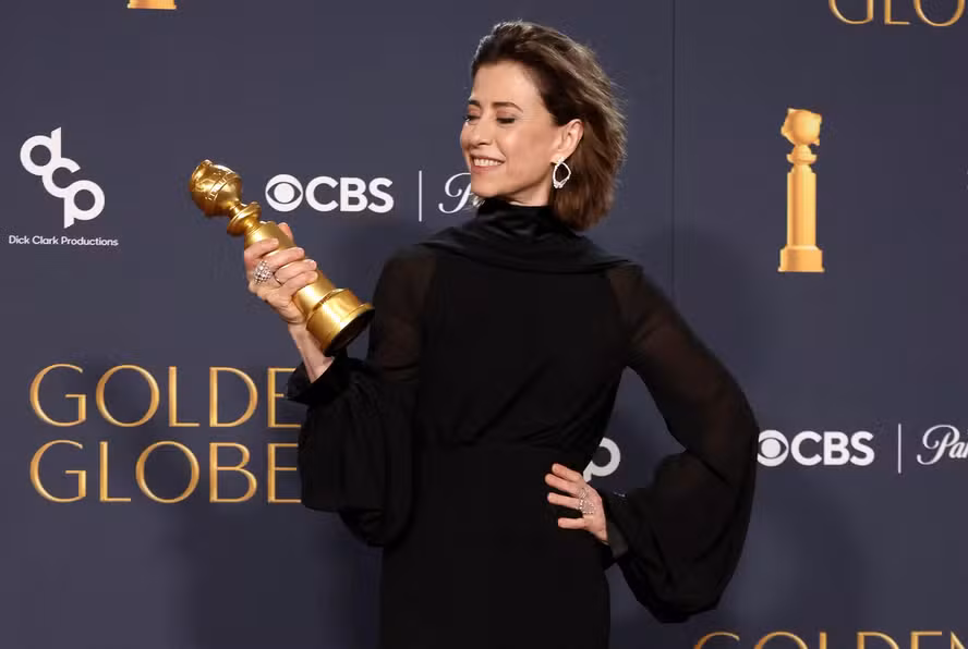Fernanda Torres segurando o Globo de Ouro no palco