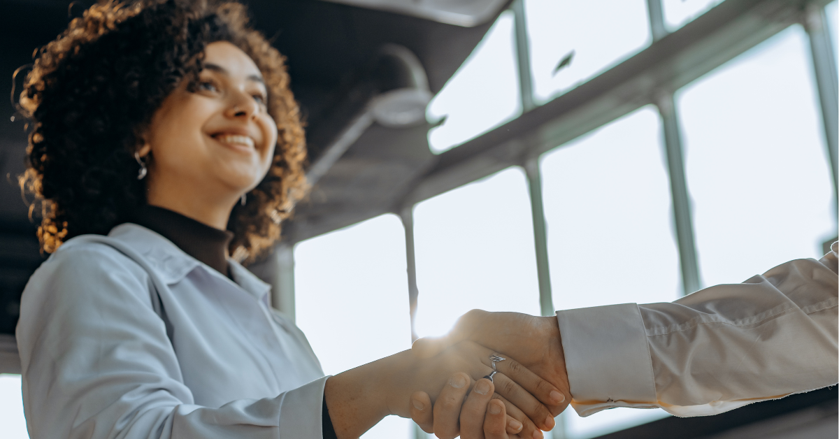 Duas mulheres apertando as mãos em uma reunião